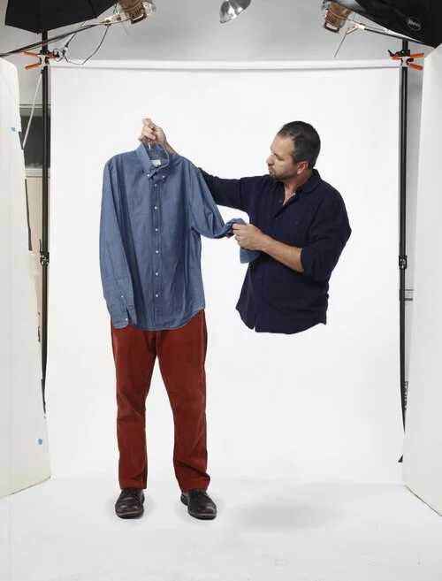 Brad Hasse holding up a shirt in a photo studio